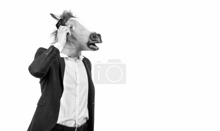 Foto de Empresario con cabeza de caballo y traje de negocios hablar en el teléfono móvil aislado en el espacio de copia blanca, la comunicación. - Imagen libre de derechos