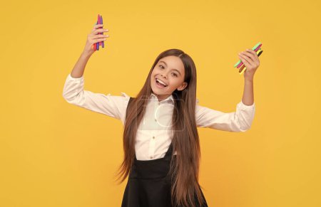 Foto de Happy school girl hold felt-tips yellow background, artistic education. - Imagen libre de derechos