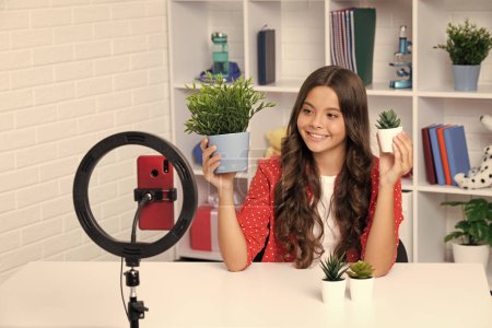 Photo for Teen girl blogger influencer use selfie led lamp and smartphone on tripod for making online video tutorial. Teenager vlogger making vlog for kids channel. Happy smiling girl - Royalty Free Image
