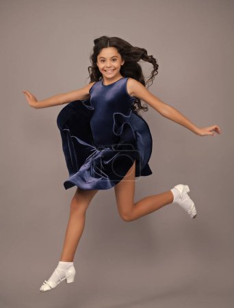 Photo for Full length teenager with movement dress. Young teen child with flowing skirt. Teen girl fluttering dress in motion, isolated on gray - Royalty Free Image