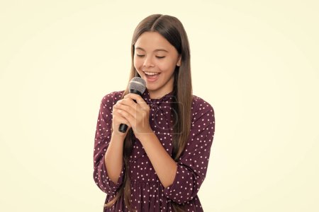 Foto de Cute girl holding a microphone and singing a song. Singer girl sings in karaoke - Imagen libre de derechos