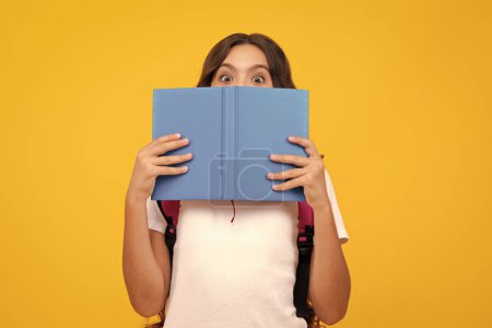 Téléchargez les photos : School teenage girl with school bag backpack hold book on yellow isolated studio background. Children school and education concept - en image libre de droit