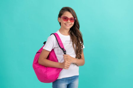 Photo for Concept of education. kid in sunglasses on blue background. september 1. happy childhood. child with school bag. smiling teen girl carry backpack. back to school. knowledge day. - Royalty Free Image
