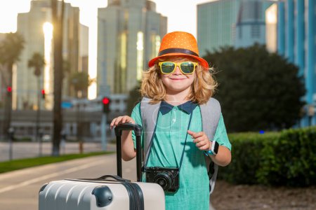 Téléchargez les photos : Voyageur enfant touriste garçon 7-8 ans. Passager voyageant à l'étranger pour voyager le week-end escapade. Enfant indépendant garçon avec grand sac de voyage - en image libre de droit