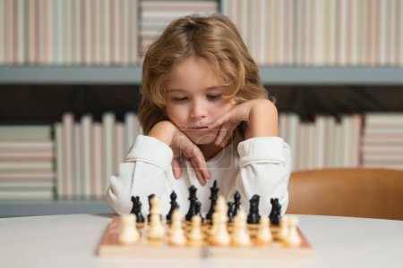 Photo for Clever concentrated and thinking kid boy playing chess - Royalty Free Image