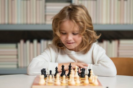 Foto de Clever concentrated and thinking child playing chess. Kids early development. Boy kid playing chess at home. Portrait close up, funny face - Imagen libre de derechos