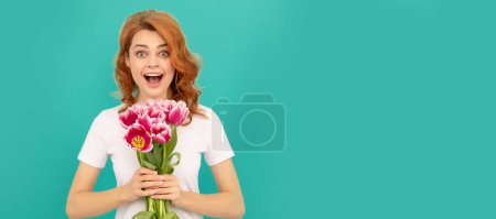 Woman isolated face portrait, banner with mock up copyspace. happy amazed girl with tulip flower bouquet on blue background