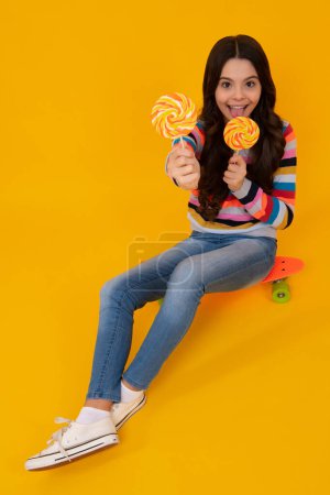Photo for Teenager girl with caramel candies on sticks, sweet sugar addiction. Child with lollipops. Happy teenager, positive and smiling emotions of teen girl - Royalty Free Image