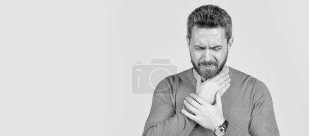 mature man with beard suffer from sore throat on grey background, cold. Man face portrait, banner with copy space