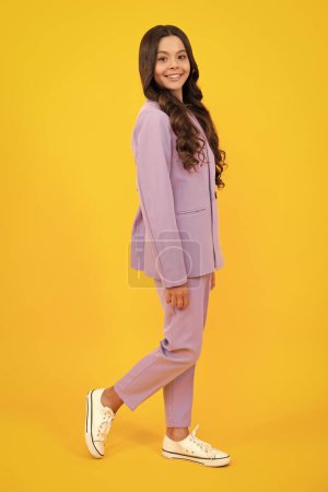 Full length photo of brunette teen girl wear casual clothes isolated on yellow background. Happy teenager, positive and smiling emotions of teen girl