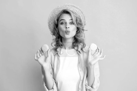 Téléchargez les photos : Portrait de jeune belle femme aux macarons. Macaron français. Fille appréciant les bonbons isolés sur fond jaune - en image libre de droit