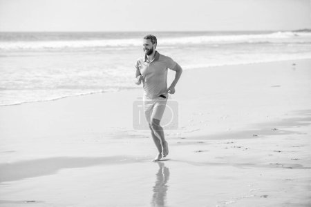 Foto de Athletic man running on summer beach for training, summer. - Imagen libre de derechos