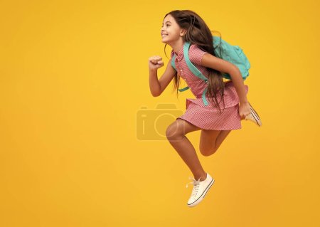 Téléchargez les photos : Je retourne à l'école. Adolescente prête à apprendre. Courir et sauter fou. Écoliers sur fond jaune isolé - en image libre de droit