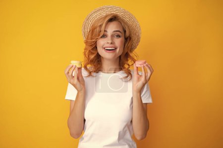 Photo for Portrait of young beautiful woman with macaroons. French macaron. Girl enjoying sweets isolated on yellow background - Royalty Free Image