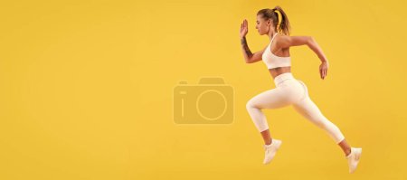 Foto de Fitness woman runner running on yellow background. Woman jumping running banner with mock up copyspace - Imagen libre de derechos