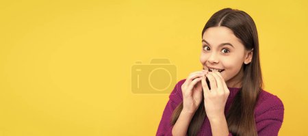 Happy kid sweet-tooth enjoy eating tasty chocolate slab yellow background, snack. Horizontal poster of isolated child face, banner header, copy space