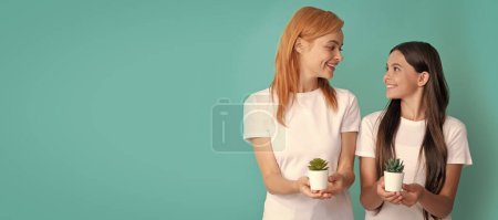 Photo for Mother and daughter child banner, copy space, isolated background. Happy woman mother and daughter child smile holding houseplants blue background, nurture - Royalty Free Image