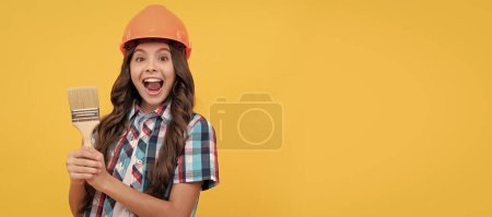 Photo for Renovation child, amazed kid with curly hair in construction helmet hold painting brush, renovator. Child builder in helmet horizontal poster design. Banner header, copy space - Royalty Free Image