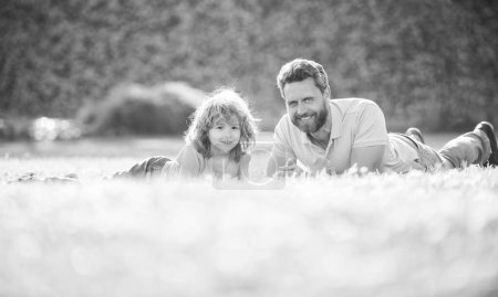 Photo for Happy family of father and son boy relax in summer park green grass, childhood. - Royalty Free Image