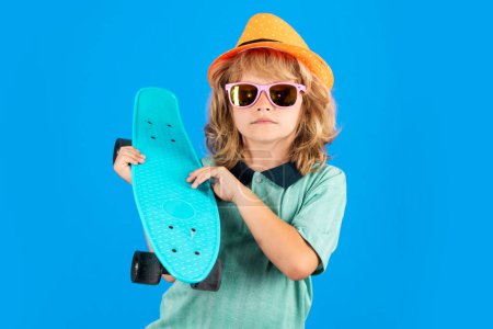 Photo for Photo of little child boy hold skateboard isolated on blue background. Casual culture. Child with skateboard and fashion stylish clothes in studio - Royalty Free Image