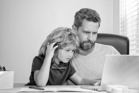 Photo for Bearded dad or school private tutor teaching boy son with modern laptop, webinar. - Royalty Free Image