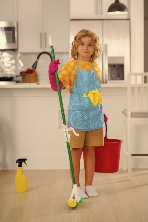 Cleaning at home. Little kid cleaning at home. Child doing housework having fun. Portrait of child housekeeper with wet flat mop on kitchen interior background