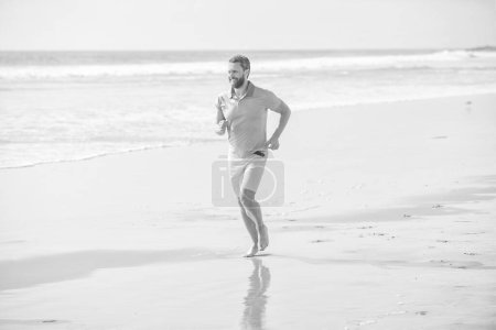 athletic man running on summer beach for training, summer.