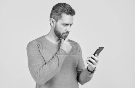 serious man with beard reading sms on smartphone, sms.
