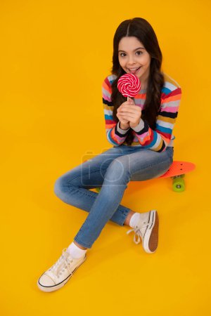 Foto de Teenager girl with caramel candies on sticks, sweet sugar addiction. Child with lollipops. Happy teenager, positive and smiling emotions of teen girl - Imagen libre de derechos
