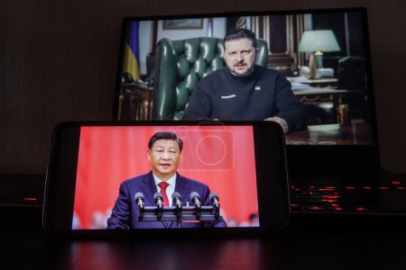 Foto de Kiev, Ucrania - 16 de marzo de 2023: el presidente chino Xi Jinping en la pantalla del teléfono y Volodymyr Zelenskyy el presidente de Ucrania en segundo plano. - Imagen libre de derechos