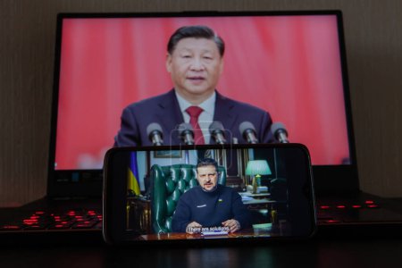 Foto de Kiev, Ucrania - 16 de marzo de 2023: El presidente ucraniano Volodymyr Zelenskyy en la pantalla del teléfono desde la presidencia, el presidente chino Xi Jinping en el fondo.dgeable sobre la situación en Beijing ha sugerido que Xi puede organizar - Imagen libre de derechos