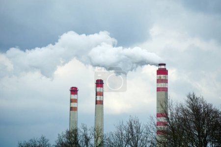 Smoking chimneys of coal power plant - air pollution - dark sky - global warming