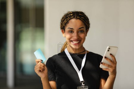 Foto de Retrato de una mujer sonriente usando tarjeta de crédito y teléfono móvil para comprar en línea - Imagen libre de derechos