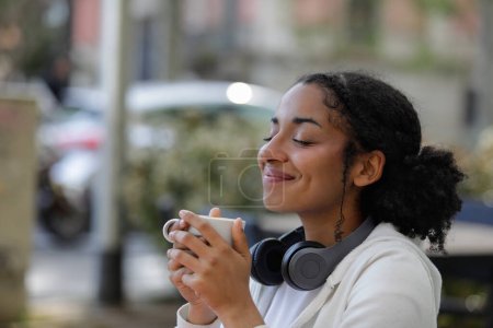 Foto de Mujer relajada disfrutando de una taza de café sentado en una terraza bar - Imagen libre de derechos