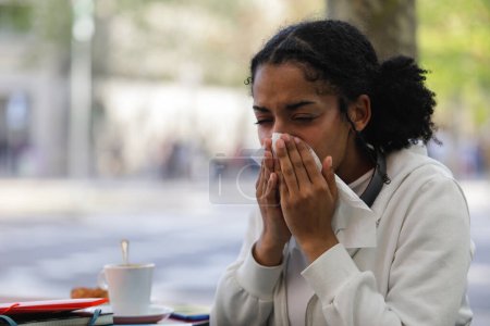 Foto de Mujer sonándose la nariz con un pañuelo. Ella tiene un resfriado o alergia. - Imagen libre de derechos