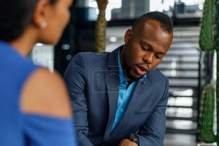 Téléchargez les photos : African american focused male professional listening and looking at partner negotiating in meeting at corporate office - en image libre de droit