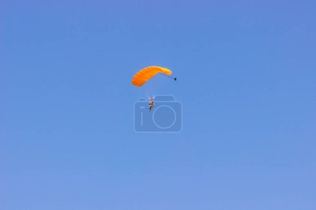 Photo for Parachutist with an orange parachute in the blue sky. - Royalty Free Image
