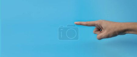 Photo for A woman's hand with an index finger on a blue background. Copy space. Banner. - Royalty Free Image