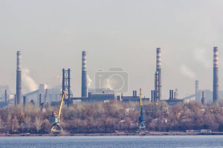 Foto de Vista de la ciudad industrial de Zaporozhye en Ucrania. Emisiones de humos de chimeneas de fábricas metalúrgicas. El problema de la contaminación ambiental y el calentamiento global. - Imagen libre de derechos
