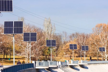 Foto de Módulos fotovoltaicos sobre farolas en el parque en otoño. El concepto de electricidad barata usando paneles solares. Zaporozhye, Ucrania. - Imagen libre de derechos