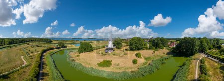 Aerial view with the windmill De Koe in Veere. In the background the inland water Veerse Meer and cityscape with town hall.. Veere is a city in the province of Zeeland in the Netherlands