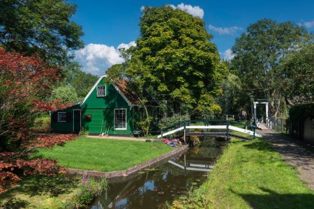 Foto de Escena del pueblo con jardines frontales y casas tradicionales en la calle Haaldersbroek en el distrito Kalverpolder de Zaandam. Provincia de Holanda Septentrional en Holanda - Imagen libre de derechos