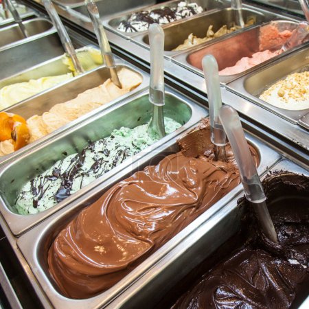 Téléchargez les photos : Plateaux de crème glacée dans diverses saveurs dans un magasin de crème glacée - en image libre de droit