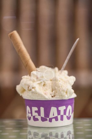 Foto de Taza con helado aislado en el fondo con conos apilados - Imagen libre de derechos