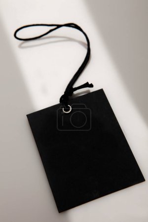 Téléchargez les photos : Étiquette noire neutre avec cordon sur fond blanc - en image libre de droit