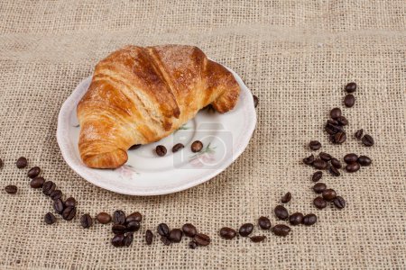 Foto de Croissant con granos de café alrededor de un saco de arpillera - Imagen libre de derechos
