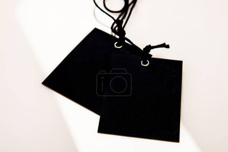Téléchargez les photos : Étiquette noire neutre avec cordon sur fond blanc - en image libre de droit