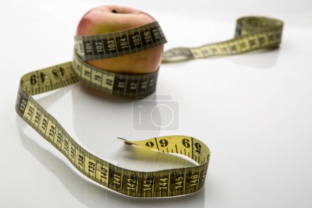 Photo for Apple with measuring tape on white background - Royalty Free Image