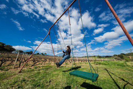 Photo for Girl having fun on a swing surrounded by nature - Royalty Free Image