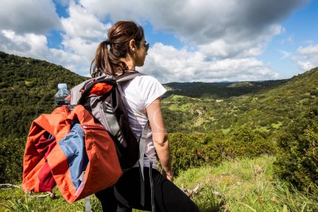 Foto de Mujer camina frente a un grupo de excursionistas en las montañas rodeados de naturaleza - Imagen libre de derechos